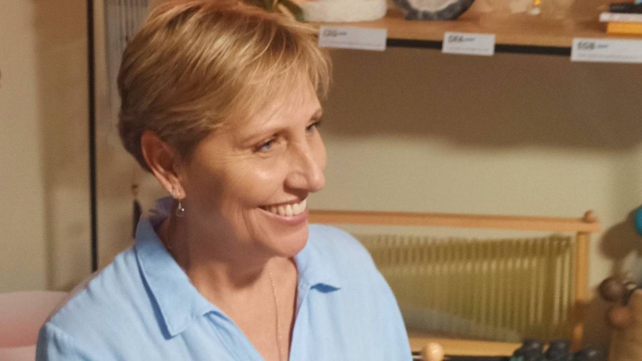 Sound healing practitioner wearing a blue top and smiling