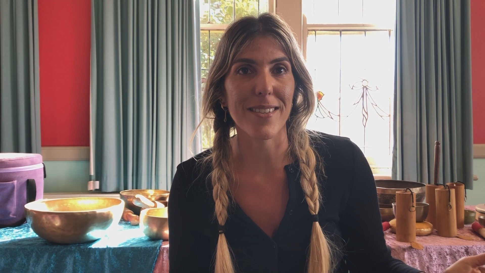 Woman with braided tails giving a sound healing academy review for the level 2 practitioner diploma workshop course in integral sound healing for working 1-2-1 with client