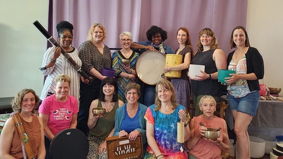 A group of people together smiling and posing during a sound healing workshop course