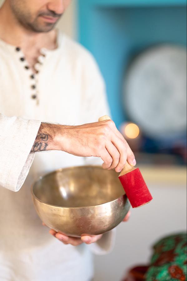 Sound Healing Practitioner playing a Tibetan bowl