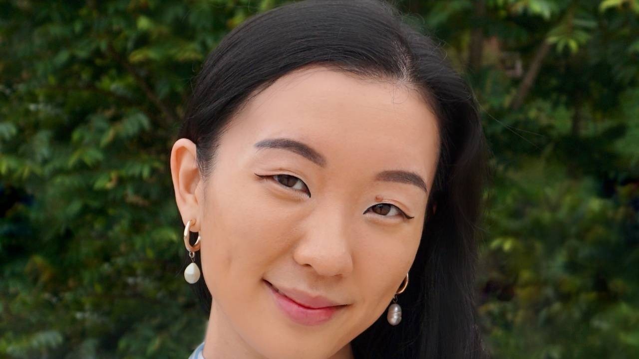 Woman with pear earrings smiling in nature
