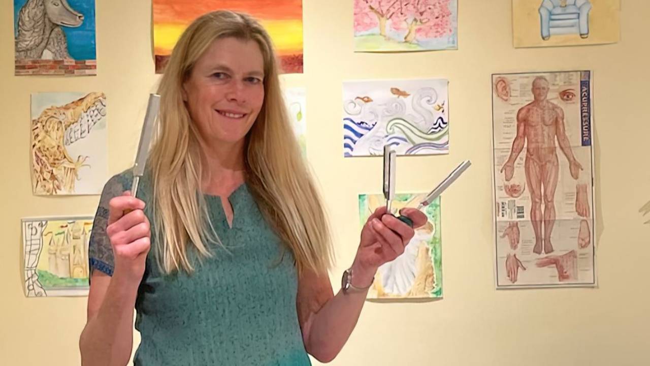 Woman with green top playing tuning forks