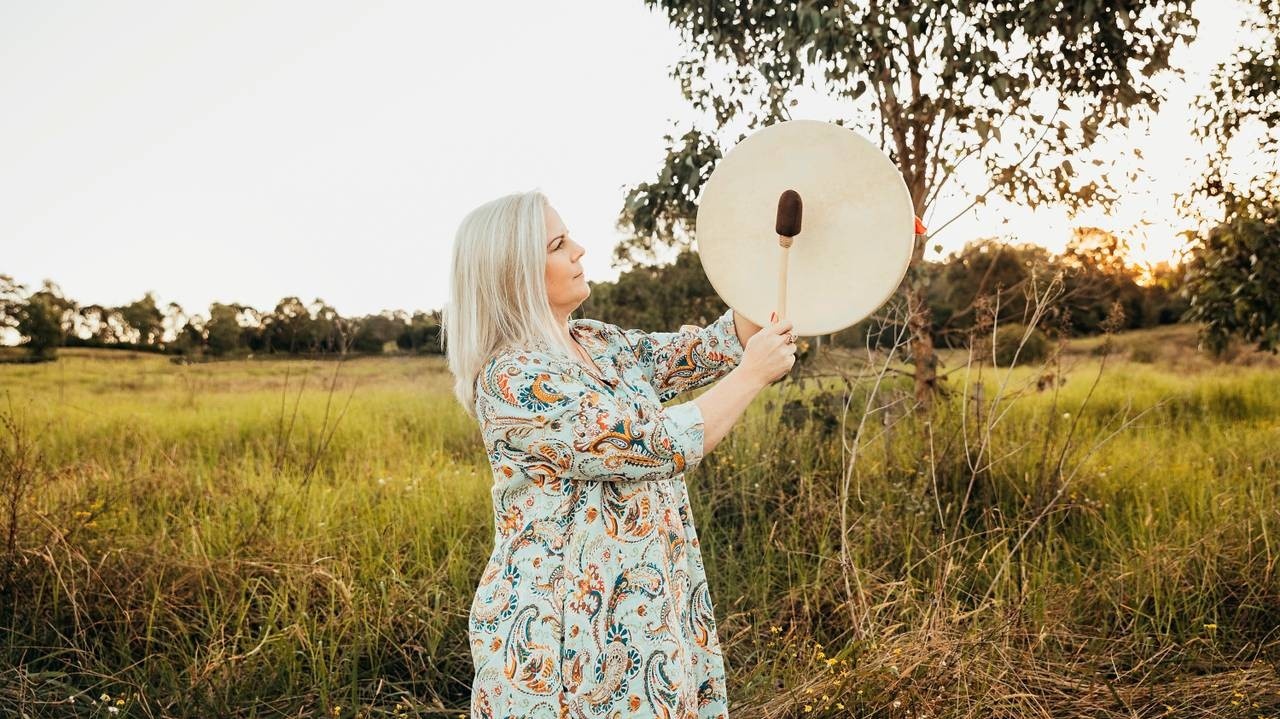 Woman in a dress playing a drum
