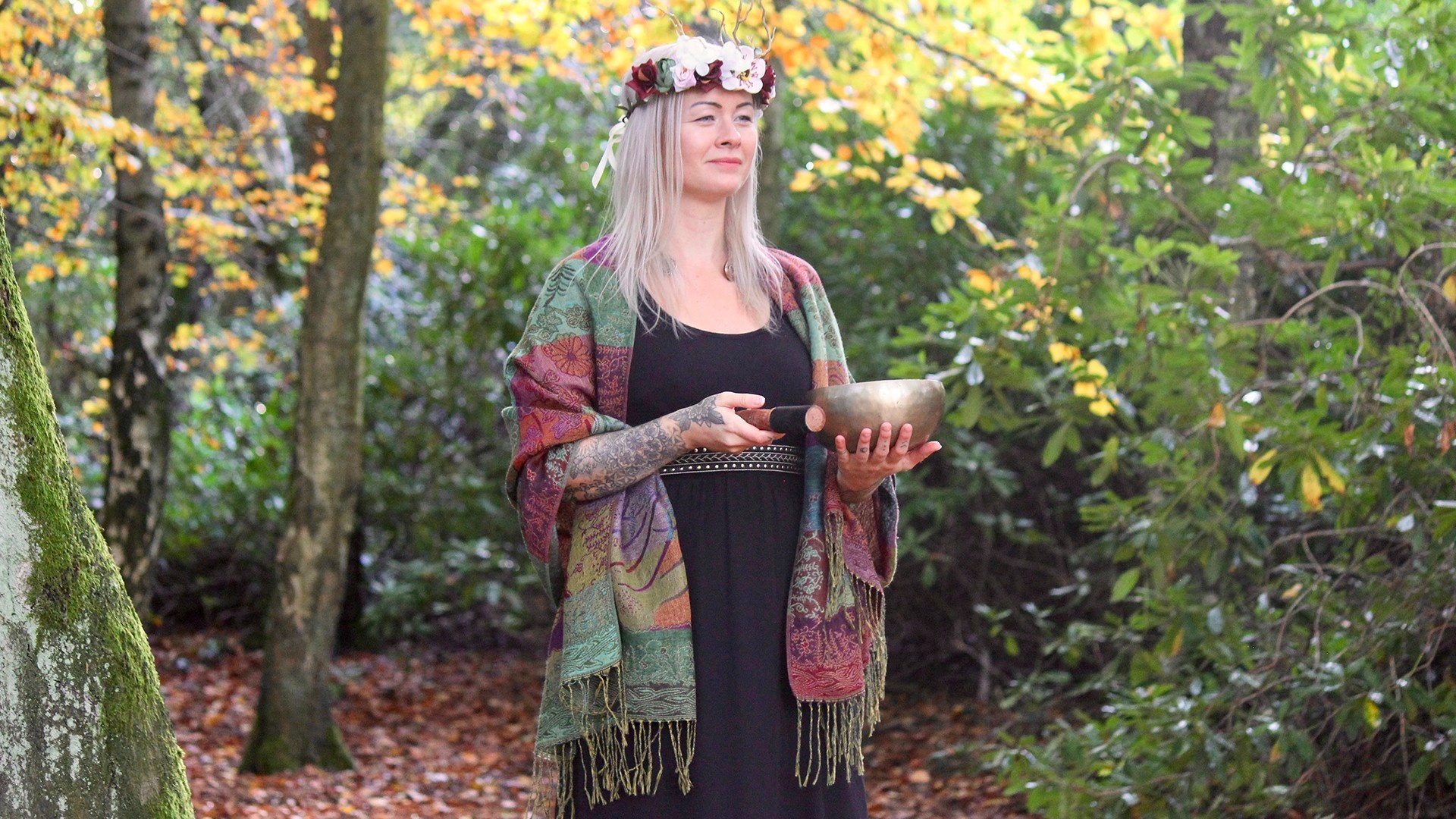 Woman with a flower crown, holding a tibetan bowl in nature