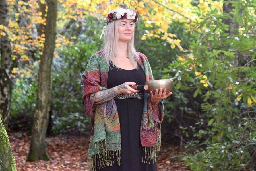 Woman holding a tibetan singing bowl in the woods